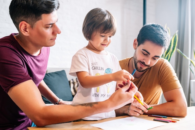 Couple gay s'amusant avec leur fils à la maison.