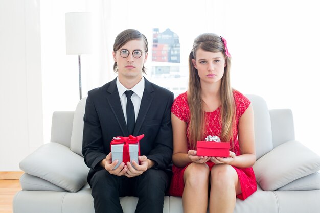 Couple geeky unsmiling avec cadeau