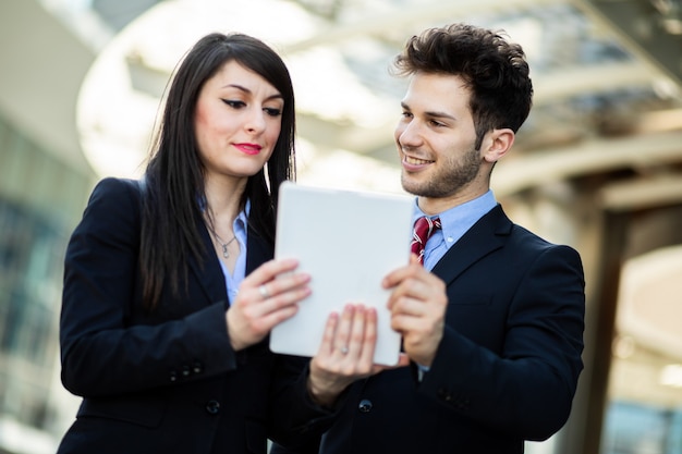 Couple de gens d'affaires à l'aide d'une tablette en plein air