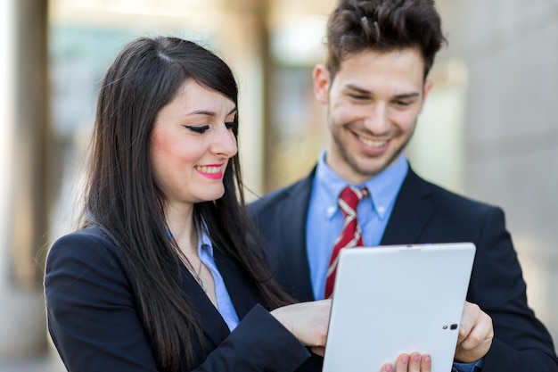 Couple de gens d&#39;affaires utilisant une tablette en plein air