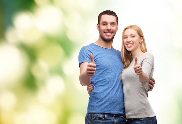 Photo couple, geste et concept de famille - couple souriant montrant les pouces vers le haut