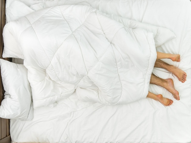 Le couple gisait sous la couverture. Vue d'en-haut