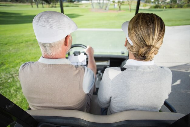 Couple de golf au volant de leur buggy de golf