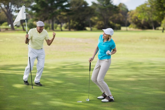 Couple de golfeurs matures célèbre le succès