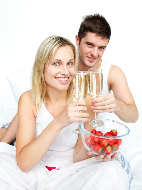 Couple grillage avec du champagne et des fraises à un fiançailles