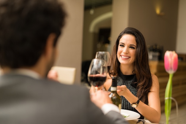 Couple grillage des verres à vin dans un restaurant de luxe. Focus sur la femme