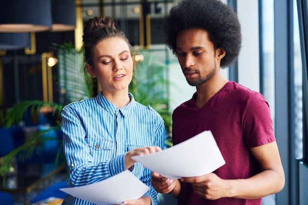 Couple hétérosexuel analysant des documents importants au bureau