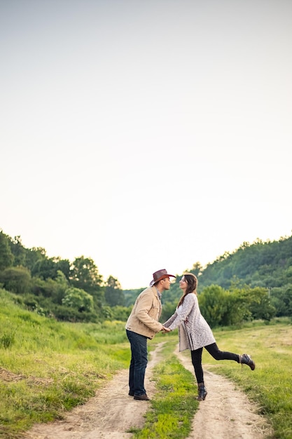 Un couple hétérosexuel caucasien marche dans l'allée en se tenant la main près d'un village pittoresque en Ukraine Photo verticale