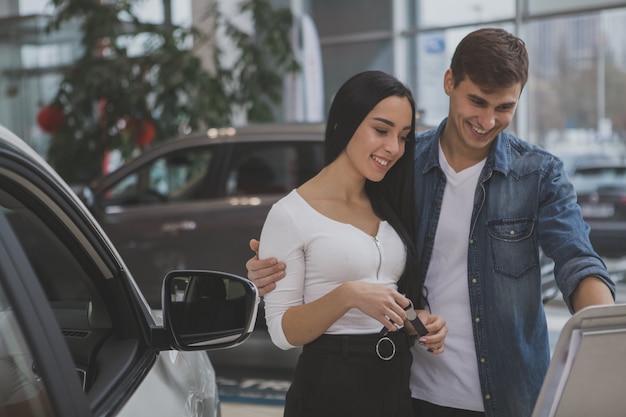 Couple heureux achète une voiture neuve chez un concessionnaire