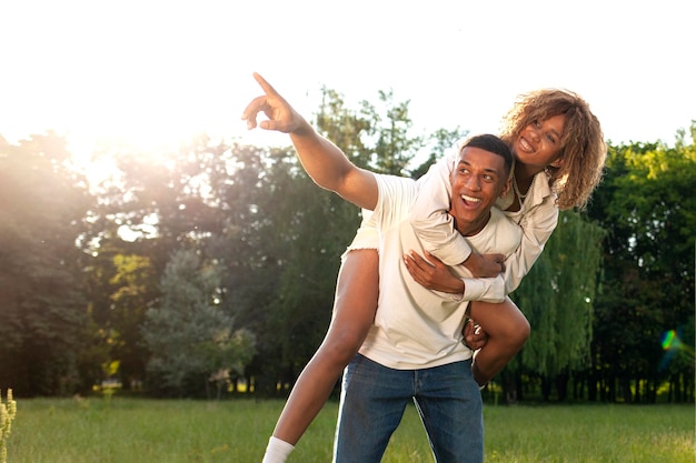 Un couple heureux afro-américain marche ensemble dans le parc en été et regarde l'espace de copie