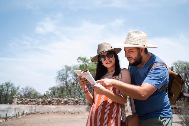 Couple heureux à l'aide d'une carte lors d'un voyage dans un concept de style de vie de voyage de paysage rustique en plein air