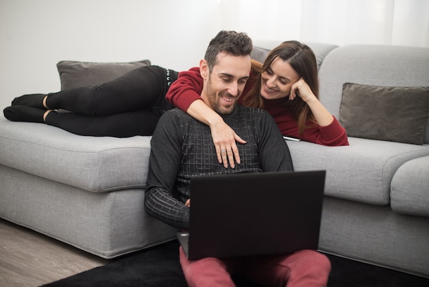 Couple heureux à l'aide d'un ordinateur portable dans leur maison