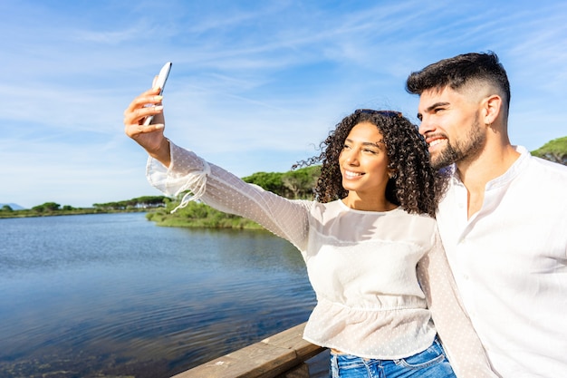 couple heureux amoureux faisant un selfie en vacances dans une station balnéaire au coucher du soleil