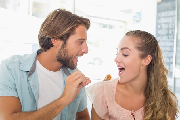 Couple heureux en appréciant un gâteau