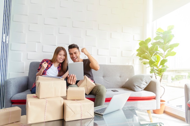 Couple heureux après la vente en ligne réussie à la maison. Petite entreprise avec le concept de technologie.