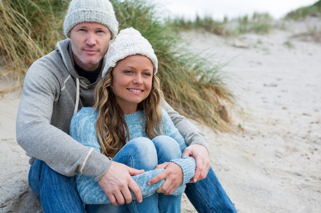 Couple heureux assis sur le rivage