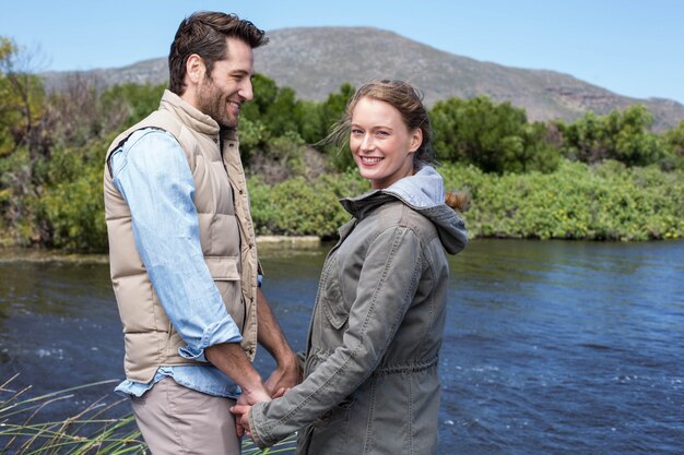 Photo couple heureux au bord d'un lac