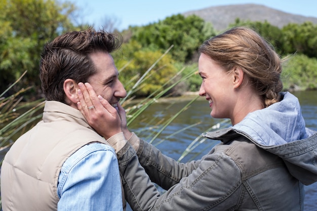 Photo couple heureux au bord d'un lac