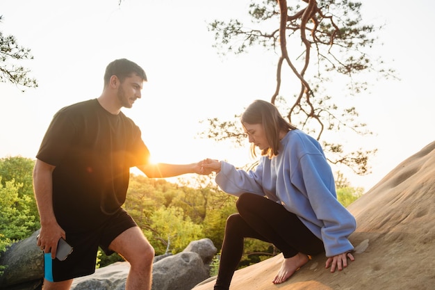 Un couple heureux au coucher du soleil sur la falaise.