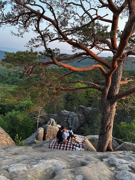 Un couple heureux au coucher du soleil sur la falaise.