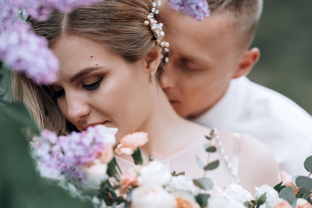 Couple heureux. belle jeune mariée et le marié avec un bouquet de mariée