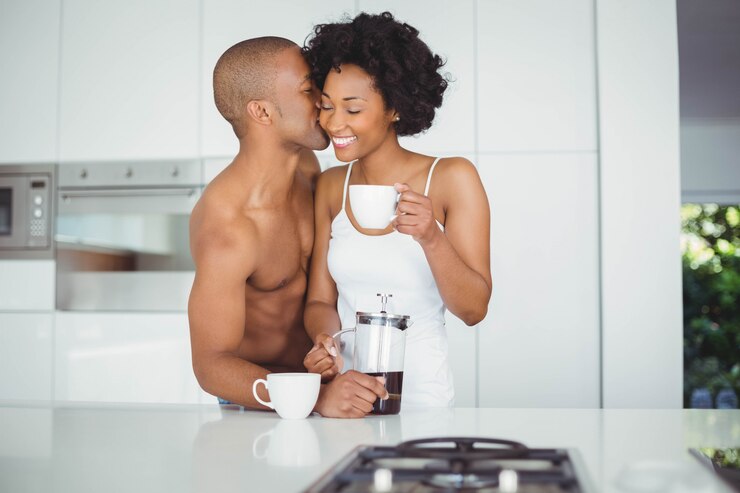 Couple heureux, boire du café dans la cuisine à la maison