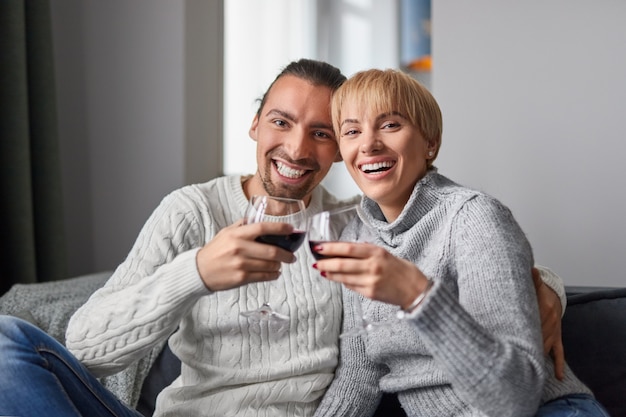 Couple heureux, boire du vin à la maison
