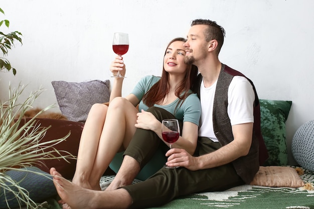 Couple heureux, boire du vin à la maison