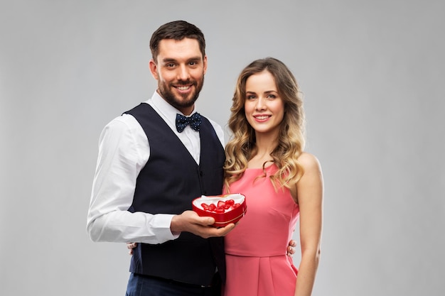 un couple heureux avec une boîte de chocolat en forme de cœur