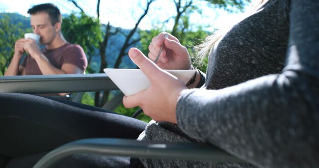 Couple heureux buvant du café et prenant son petit déjeuner sur un beau balcon