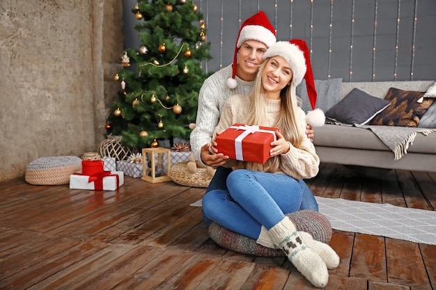 Couple heureux avec un cadeau de Noël à la maison