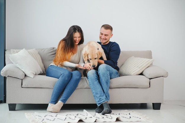 Couple heureux avec chien dans le salon