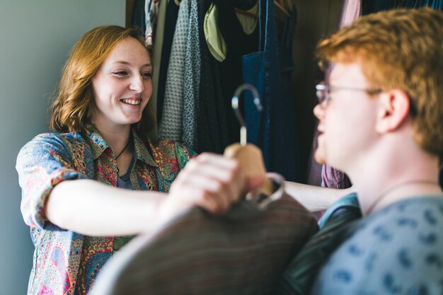 Couple heureux choisir des vêtements à côté de la garde-robe