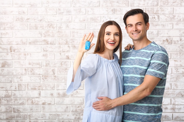 Couple Heureux Avec La Clé De Leur Nouvelle Voiture Sur Le Mur De Briques