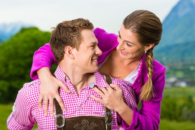 Couple heureux dans une prairie alpine en Tracht