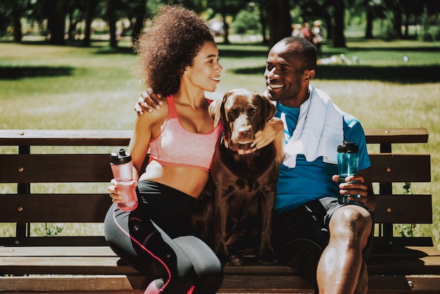 Couple heureux dans Sportswear Petting Adorable Brown Dog