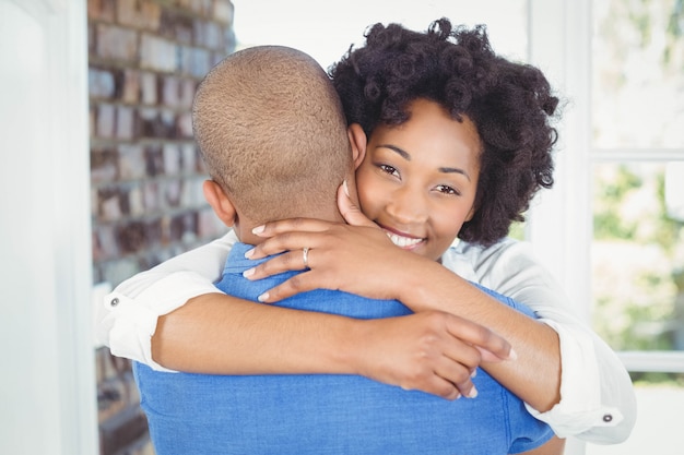 Couple heureux embrassant de leur maison