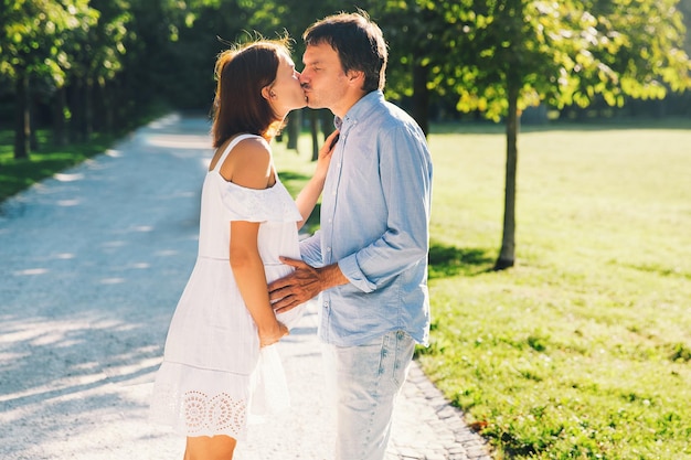 Couple heureux et enceinte étreignant dans la nature d'été Belle femme enceinte et mari à l'extérieur