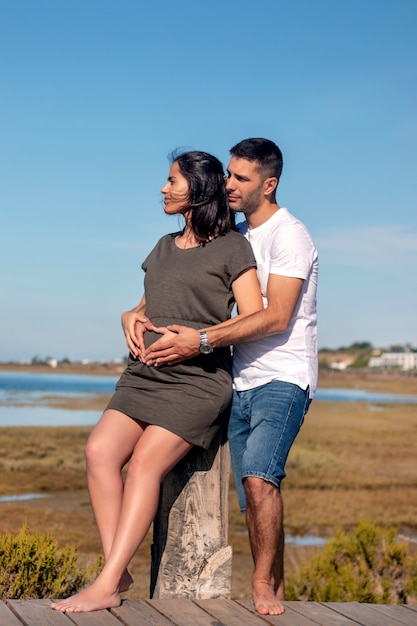 Couple heureux enceinte à la plage