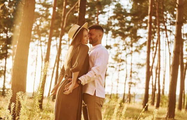 Un couple heureux est à l'extérieur dans la forêt pendant la journée