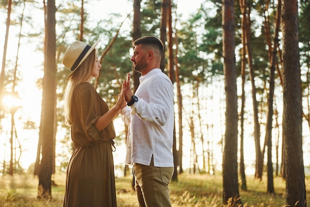 Un couple heureux est à l'extérieur dans la forêt pendant la journée