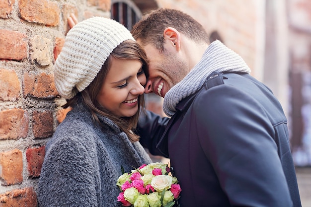 couple heureux étreignant avec des fleurs dans la ville