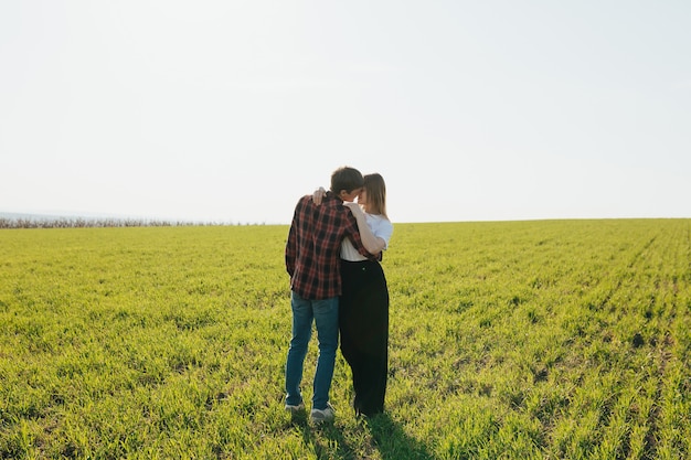 Couple heureux étreint sur la campagne sur le champ vert.