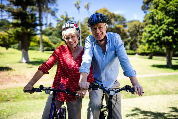 Couple heureux, faire du vélo dans le parc