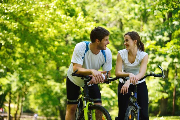 Couple heureux faire du vélo à l'extérieur, concept de romance d'amour amusant de mode de vie de santé