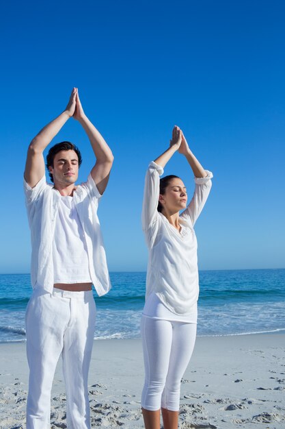 Couple heureux, faire du yoga au bord de l&#39;eau