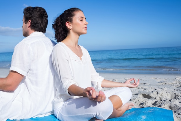 Couple heureux, faire du yoga au bord de l&#39;eau