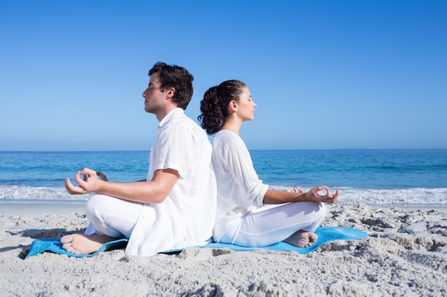 Couple heureux, faire du yoga au bord de l&#39;eau