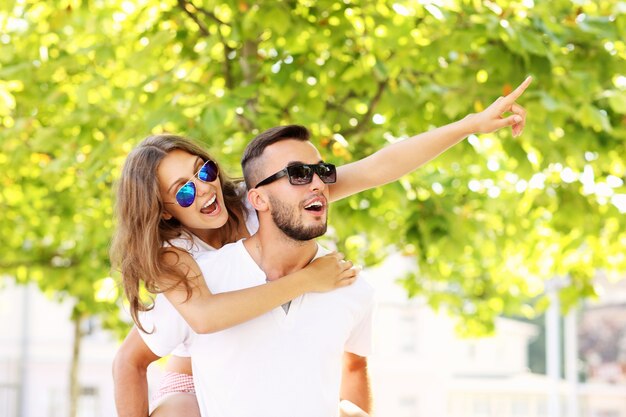 un couple heureux faisant le ferroutage et pointant du doigt quelque chose dans le parc