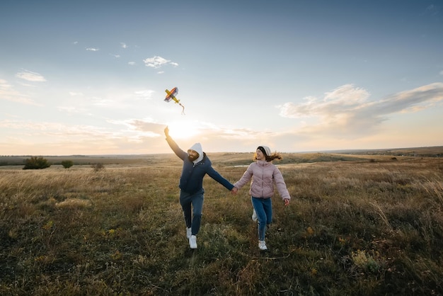 Un couple heureux fait voler un cerf-volant et passe du temps ensemble au grand air. Relation heureuse et vacances en famille.